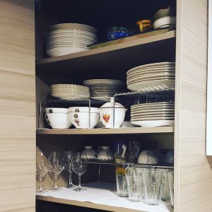 kitchen dishes storage metal shelf risers display tea cups and glassware Bella Organizing Professional home organizers and residential packing and moving management company serving the San Francisco Bay Area.
