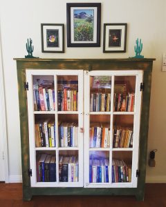 Colorful books on living room bookshelf with glass doors Bella Organizing Professional home organizers and residential packing and moving management company in the san francisco bay area