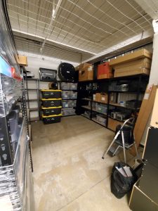 storage unit declutter and organize metal shelves and black bins with yellow lids from Costco built by Bella Organizing Professional home organizers and residential packing and moving management company serving the San Francisco Bay Area.
